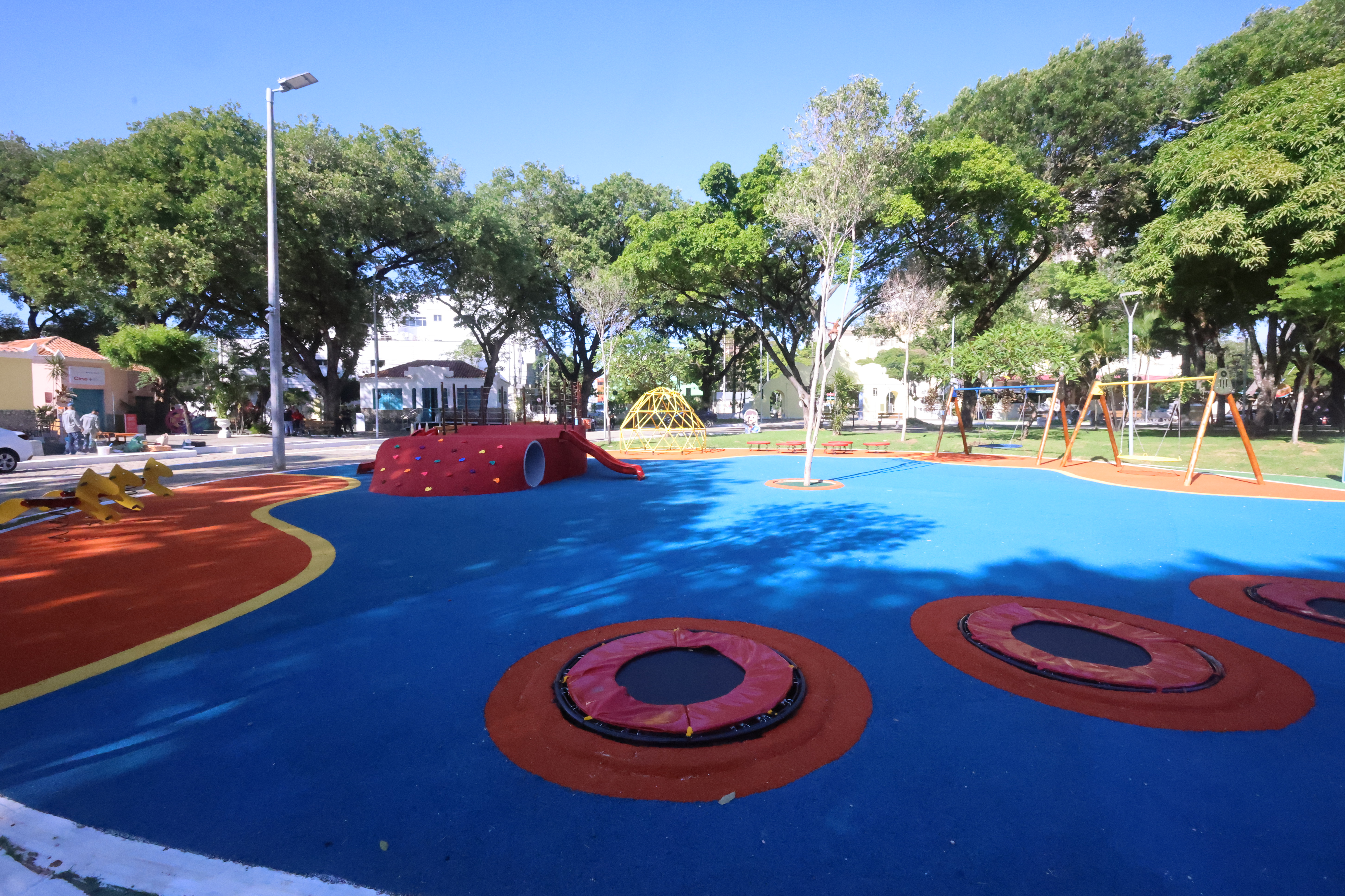 a imagem mostra um piso todo colorido, pintado de azul, amarelo e vermelho no interior da Cidade da Criança